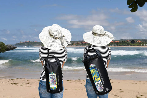 Two people with Waterproof Dry Bag Set Of 3 With Double Zip Locks Includes Waist Pouch And IPX8 Phone Case at the beach.