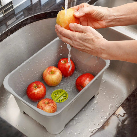Heavy Duty Plastic Sink Wash Basin For Dishes, Large Multipurpose Dishpan With Drain Plug, gray basin with apples being washed