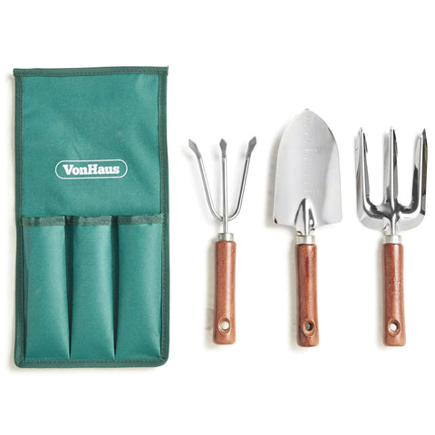 Garden tool set with green bag, metal trowel, fork, and rake on display.