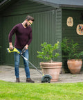 Person using 18V ONE Plus Cordless Edger Bare Tool With 22cm Serrated Edging Blade, Four Position Height Adjustment, Dual Guide Wheels, Debris Guard on lawn.
