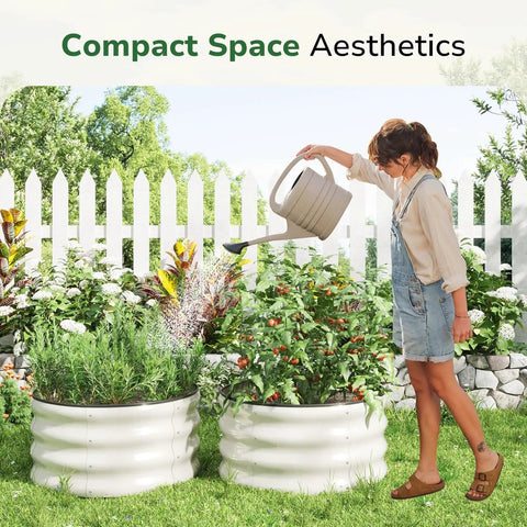 Woman watering plants in round galvanized raised garden bed 2x2x1 ft for vegetables in yard with white picket fence