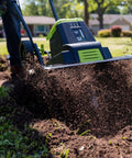 Corded Electric Garden Tiller Cultivator With 12.5 Amp Motor 16 Inch Tilling Width slicing through soil in a garden setting