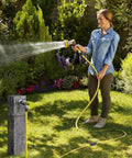 Fix Your Leak In No Time With This Heavy Duty 3/4 Inch Garden Hose Repair Kit Featuring Upgraded Aluminum Clamps And Extra Washers For A Total Zero Leak Fix. Woman watering garden with yellow hose and repair clamps on sprinkler line.