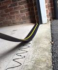 Close-up of Beefed Up Garage Door Threshold Seal Kit with adhesive being applied to 10 ft 6 in door threshold, weatherproof seal visible