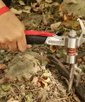 Close-up of a hand using a Heavy Duty Shock Absorbing Camping Hammer Low Vibration Mallet for driving tent stakes.