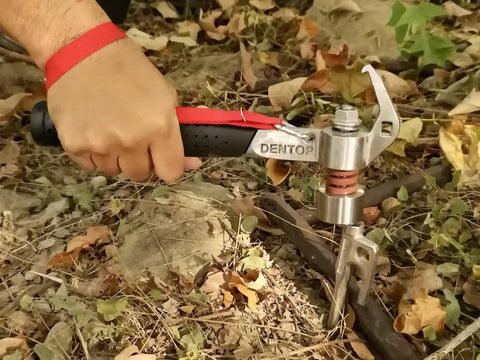 Close-up of a hand using a Heavy Duty Shock Absorbing Camping Hammer Low Vibration Mallet for driving tent stakes.