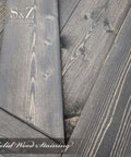 Close-up of deep gray finish on solid wood spruce barn door panels showing natural wood grain texture.