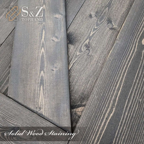 Close-up of deep gray finish on solid wood spruce barn door panels showing natural wood grain texture.