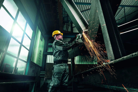 Worker using Heavy Duty 6-Inch Angle Grinder With Brake, Anti-Vibration, 14.5 Amp, in industrial setting with sparks