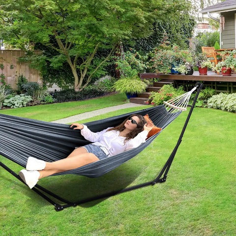 Person relaxing on 2 In 1 Hammock And Swing Chair With Collapsible Steel Stand And Carrying Case Portable And Adjustable in garden