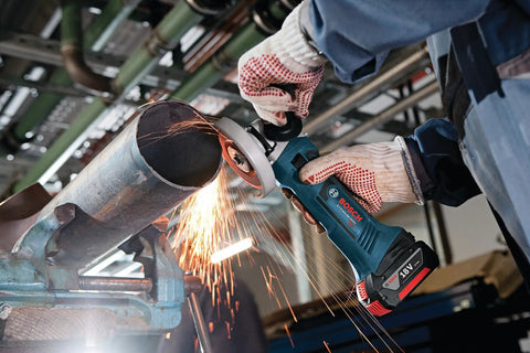 Worker using 18V Cordless Angle Grinder 4-1/2 Inch Bare Tool With All Day Power on a metal pipe, sparks flying