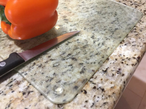 Glass cutting board on granite with 100 Clear Cabinet Door Bumpers Half Inch Self Adhesive Rubber Feet Pads visible underneath.