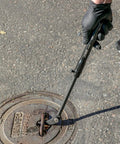 Extendable Pry Bar With 13.3 To 18.5 Inch Reach 14 Position Adjustable Angled Head lifting a manhole cover