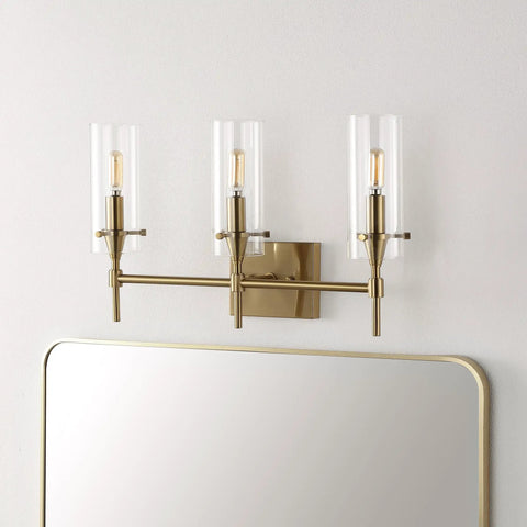 Brass Gold Modern Farmhouse LED Vanity Light Sconce With Clear Glass Cylinder Shade above mirror, three lights, wall mounted