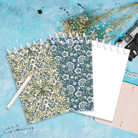 Mini Pocket Spiral Notebooks Bundle - 24 Count, 2.36 x 3.94 Inches, 8 Vintage William Morris Floral Covers, on blue background.