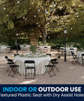 Hercules Set Of 10 Indoor Outdoor Heavy Duty Plastic Folding Chairs around tables in an outdoor event setting, black.