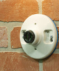 Polarized Handy Plug 2 Pack Light Socket To 2 Prong Outlet Adapter installed on brick wall