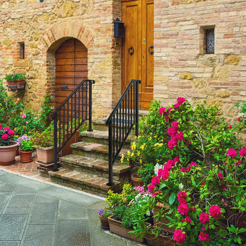 Heavy Duty Wrought Iron Handrails For Outdoor Steps with flowers and stone stairs leading to a wooden door.