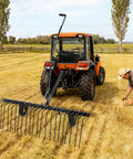 60 Inch Tow Behind Landscape Rake For ATVs And Mowers, Beefy Steel Teeth Dethatcher And Pine Straw Rake in field with tractor