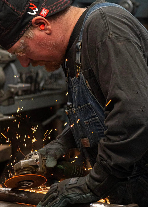 Worker using a grinder wearing an 8 Panel Welding Beanie Cap For Protection 100% Cotton Duck Canvas Exterior Heavy Duty Welder Hat For Men