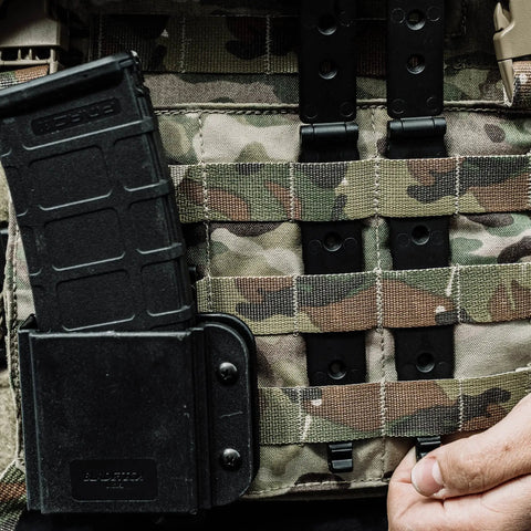 Rock Solid 3 Inch Molle Lok Clips attaching a magazine holder to a tactical vest with camo webbing.