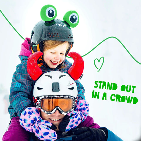 Child wearing a helmet with Totally Fun Frog Helmet Accessory Set With Sticky Hook And Loop Fastener Adhesive Eyes And Ears Cover For Snowboarding Skiing Biking Cycling Skating For Kids And Adults Helmet Not Included on top of adult's helmet with red accessories.