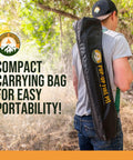 Man carrying portable 24 inch collapsible fire pit for camping and backyard, lightweight pop up campfire pit in black bag