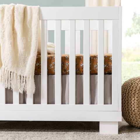 Modo 3 In 1 Baby Crib That Converts To Toddler Bed And Daybed Includes Toddler Conversion Kit Solid Wood Crib For Baby With Four Adjustable Heights White GREENGUARD Gold Certified with a beige blanket draped over the side