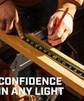 Close-up of a builder using the Workhorse Nite Eye Tape Measure 25 Ft 2 Pack With High Contrast Blade for precise measurements in low light.