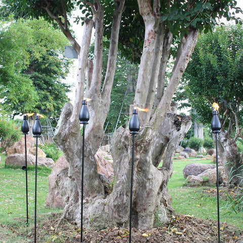 Citronella Torches 6 Pack for Outdoor Lighting with flickering flame in a garden setting, showcasing 60 inch jet black metal pathway torches.