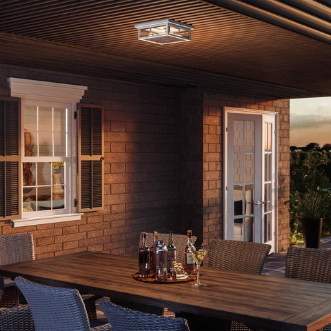 Westover Outdoor Exterior Flush Mount Ceiling Light With Clear Beveled Glass illuminating a patio setting with table and chairs.