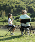 Two people sitting by a lake on Extra Large Quick Folding Tripod Stool With Backrest For Fishing And Camping Built Tough Beefy Portable Chair