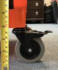 Close-up of RBC-323 Roll A Bucket with 3 inch caster wheel and brake measuring height on carpeted floor
