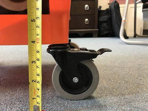 Close-up of RBC-323 Roll A Bucket with 3 inch caster wheel and brake measuring height on carpeted floor