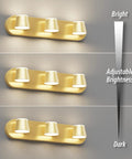 Gold three-light LED fixture demonstrating adjustable brightness levels on a wall.