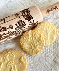Mini Embossed Rolling Pin Set Of 3 With Bees, Meadow And Forest Patterns for cookies, made of beech wood, shown with embossed cookies.