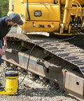 Worker using Heavy Duty Grease Gun With 10,000 Psi Output For Fast No Sweat Lubrication on construction equipment