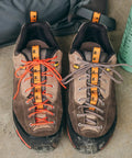 Two hiking shoes with Paracord 175 Lightweight Visible Guyline For Tents And Tarps Reflective Orange 100 Ft as shoelaces.