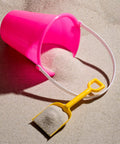 Pink bucket and yellow shovel on sand, from 12 Pack Kids Beach Buckets And Shovels Set Five Point Five Inch Small Sand Toys