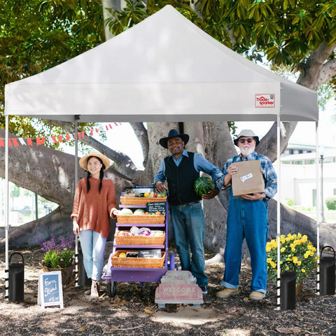 People under canopy with fruits and vegetables, canopy leg weight bags visible, illustrating use of Canopy Leg Weight Bags 4-Pack.