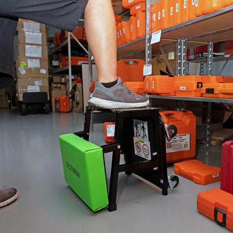 2 In 1 Mechanic Stool And Step Stool With Rolling Seat Adjustable Height Thick Padded Vinyl Cushion 300 Lb Capacity Five Swivel Casters For Auto Repair And Shop Tasks Pro Grade Comfort in a garage setting with foot on step