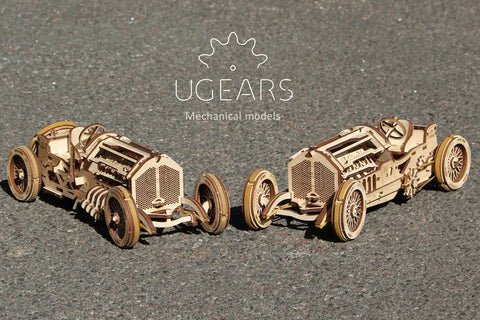 3D Wooden Puzzle Car Kit Inspired By Classic Grand Prix Racer With A Fully Functional V8 Engine, Ultra Detailed U9 Style Mechanical Model You Build And Enjoy, A Hands On Racing Car Project For Adults And Teens. two wooden race car kits on asphalt