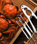 Stainless Steel Nutcracker Seafood Sheller With Dual Diameter Crushing Cones, Beefy Heavy Duty Crab Lobster Claw Opener on wood mat
