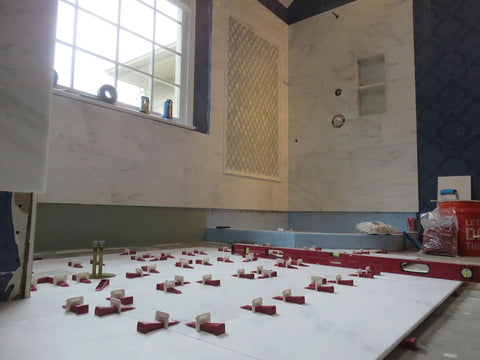One Eighth Inch T Lock Tile Leveling Kit with 300 Spacers and 100 Wedges in use on large-format tile floor installation