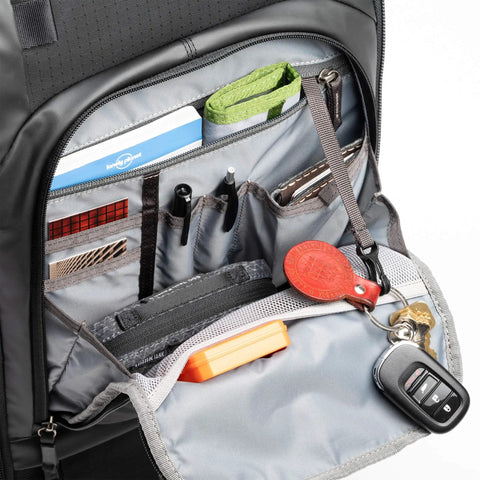 Open front panel of Walker Pro Rolling Camera Backpack showing organized compartments with accessories and camera gear.