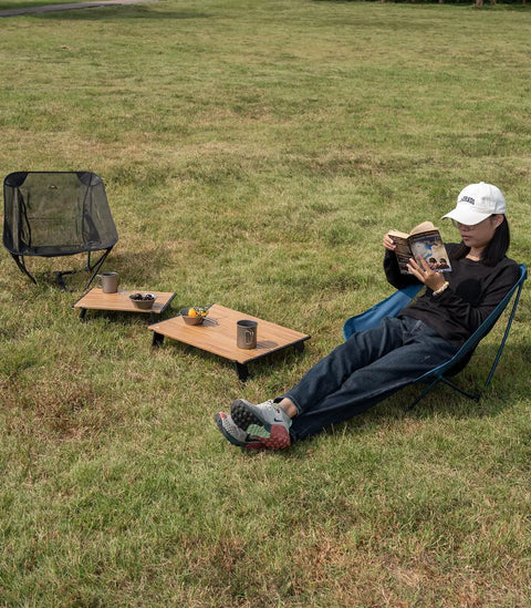 Person relaxing with Ultralight Compact Mini Beach Picnic Folding Aluminum Table With Carry Bag Nature Finish Flat Surface Durable Hinges