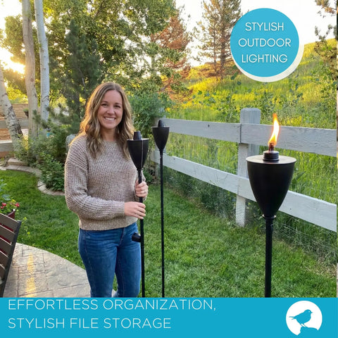 Woman holding Conical Bronze Outdoor Torch Set For Backyards And Patios, Weather Resistant, installed in garden, lit during evening