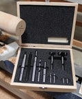 Premium Four Piece Forstner Bit Set Built For No Headache Splinter Free Cuts displayed in wooden case on wood lathe.