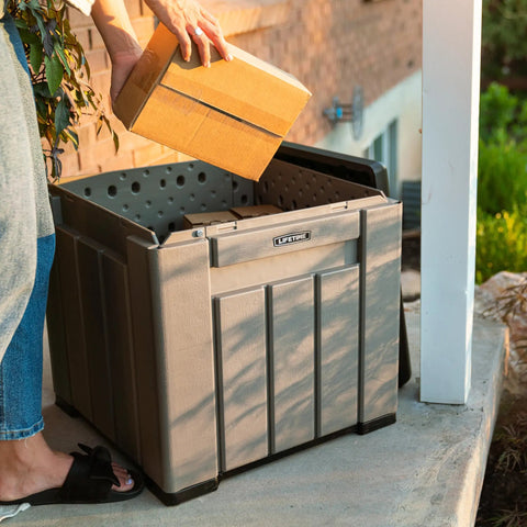 Person placing box into Versatile Outdoor Storage Cube Deck Box, weather resistant, 25-gallon capacity for porch use.