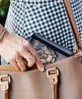 Person placing passport in RFID Blocking Leather Passport Holder Travel Wallet For Women And Men, Dark Blue in a handbag.